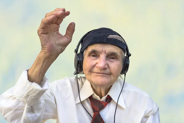 Felice donna anziana con le cuffie ascoltare musica . — Foto Stock