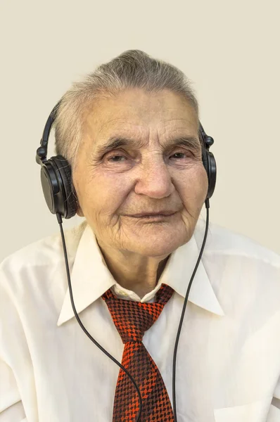 Oudere vrouw met koptelefoon luisteren naar muziek. — Stockfoto