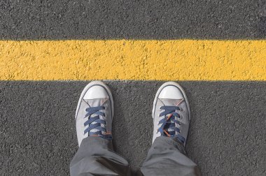 Sarı sokak satırlarının yanında ayakta.