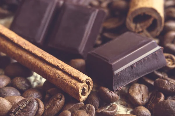 Primer plano de palitos de canela, bloques de chocolate en granos de café . — Foto de Stock