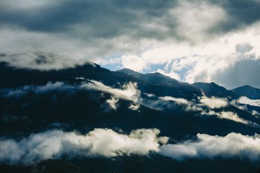 Bled, Slovenya yakınlarındaki Sloven dağlarının muhteşem manzarası. Yağmurlu bir günün ardından sisli dağların ardında güneş ışığı.