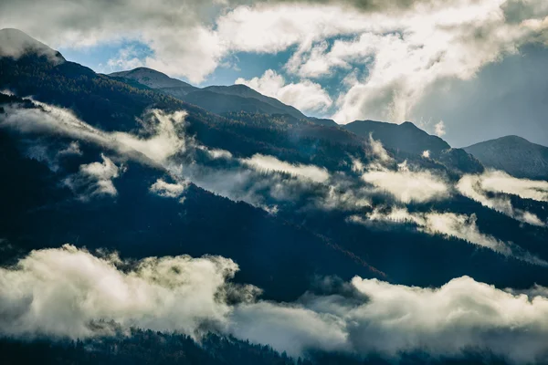 Increíble vista de las montañas eslovenas cerca de Bled, Eslovenia. Sol detrás de montañas brumosas después de un día lluvioso . — Foto de Stock