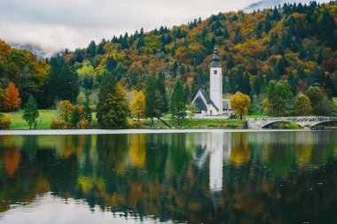 Renkli sonbahar sahne, ünlü Kilisesi St John the Baptist, Bohinj Gölü, Ribicev Laz, Slovenya'da turistik köy muhteşem görünümü