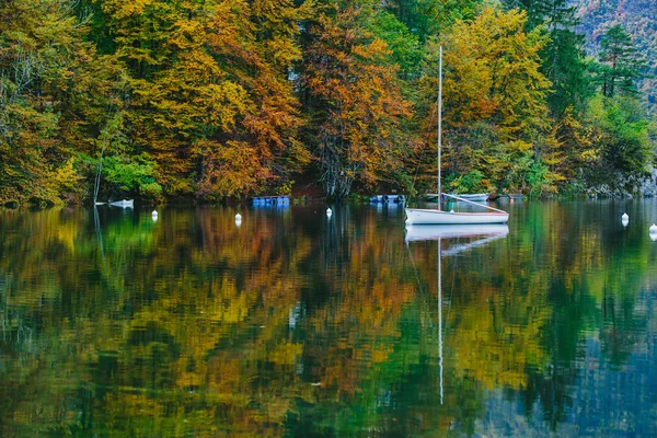 Herbstliche Aussicht auf Boote auf dem Bohinjer See, umgeben von bunten Wäldern. Slowenien, Europa — Stockfoto