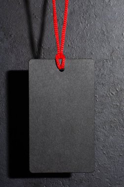 Siyah etiket sallanıyor. Koyu beton arka plan. Kara Cuma 'da tatil satışları fikri. Boşluğu kopyala.