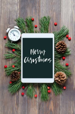 Ahşap bir arka planda Noel ya da yeni yıl geçmişi. Aygıt ekranındaki el yazması yazı