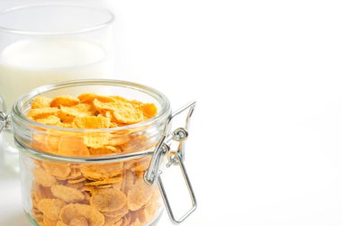 Cam bir kapta mısır gevreği ve süt. Beyaz arka plan. Boşluğu kopyala