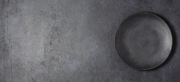 Koyu gri desenli beton arka plan, siyah yemek tabağıyla tasarlanmış. Boşluğu kopyala — Stok fotoğraf