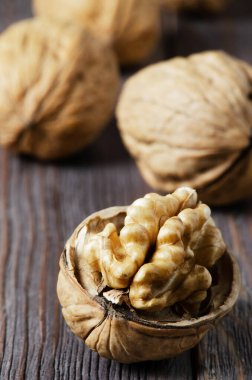 Koyu kahverengi ahşap arka planda cevizler. Kapatın. Seçici odaklanma, yan görüş. Anlaşıldı.