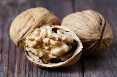 Koyu kahverengi ahşap arka planda cevizler. Kapatın. Seçici odaklanma, yan görüş. Anlaşıldı.