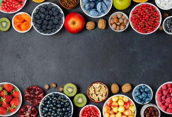 Food with a high content of antioxidants: berries, nuts, fruits. Black concrete background. Copy space