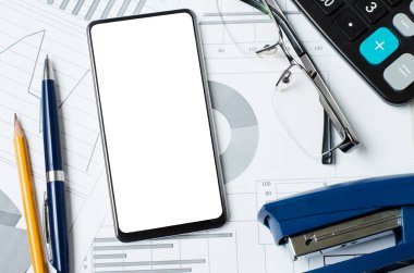 Grafiklerin ve grafiklerin arka planında boş bir ekran olan akıllı telefon. Uzayı kopyala Çevrimiçi yatırım, iş veya hisse senedi ticareti kavramı.