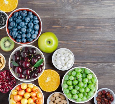 Taze böğürtlen, fıstık ve meyve karışımı. Sağlıklı yiyecekler bol miktarda vitamin ve kullanışlı elementler içerir. Kahverengi ahşap arka plan. Boşluğu kopyala.