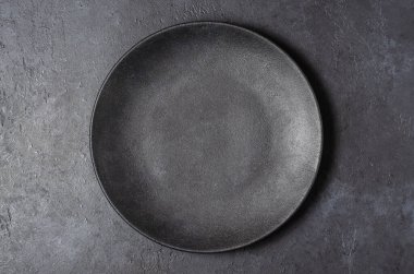 Koyu gri desenli beton arka plan, siyah yemek tabağıyla tasarlanmış. Boşluğu kopyala