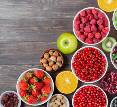 Taze böğürtlen, fıstık ve meyve karışımı. Sağlıklı yiyecekler bol miktarda vitamin ve kullanışlı elementler içerir. Kahverengi ahşap arka plan. Boşluğu kopyala