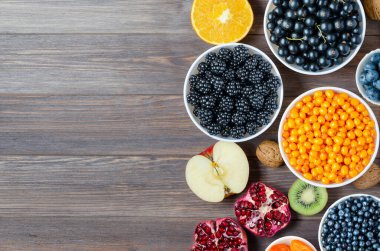 Taze böğürtlen, fıstık ve meyve karışımı. Sağlıklı yiyecekler bol miktarda vitamin ve kullanışlı elementler içerir. Kahverengi ahşap arka plan. Boşluğu kopyala