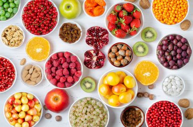 Taze böğürtlen, meyve, beyaz ahşap arka planda fındık. Sağlıklı beslenme kavramı. Yiyecek vitamin ve eser elementler içerir.