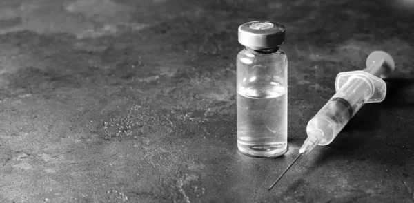 Karanlık bir arka planda şırınga ve ilaç. Viral enfeksiyon ya da uyuşturucu bağımlılığına karşı aşı kavramı — Stok fotoğraf