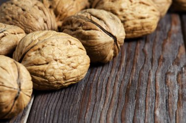 Koyu kahverengi ahşap arka planda cevizler. Kapatın. Seçici odaklanma, yan görüş. Boşluğu kopyala.