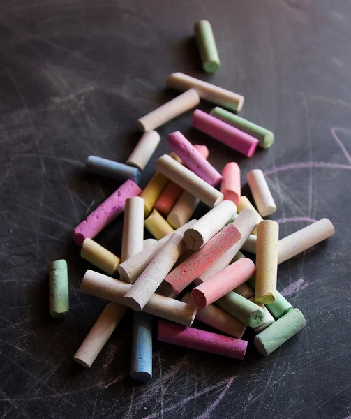 Colored chalk on the chalkboard Royalty Free Stock Images