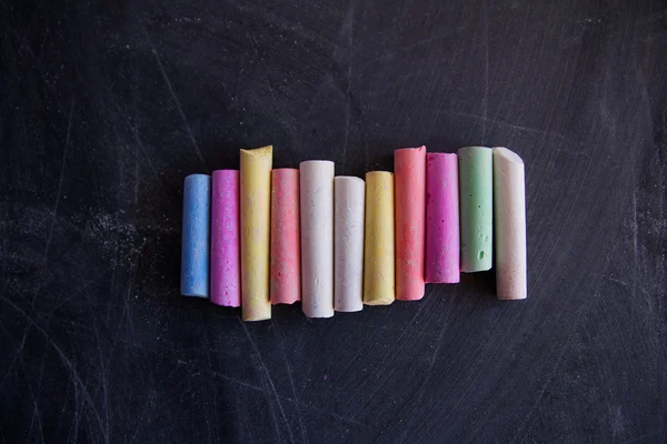 Colored chalk on the chalkboard Stock Picture