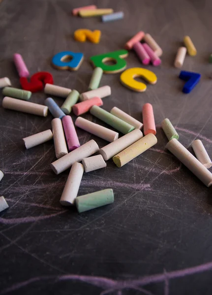 Colored chalks numbers and letters on blackboard — Stock Photo, Image