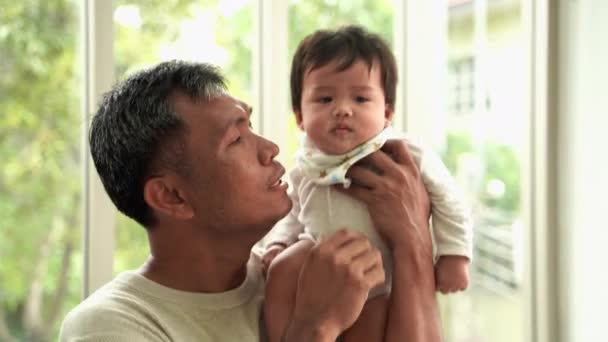 Grandfather holding grandson and kissing on the cheek, Asian family