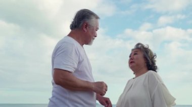 Yaşlı Asyalı çiftler, tıpkı dünkü gibi, romantik bir deniz kenarında öpüşüp kucaklaştıklarını söylüyorlar..