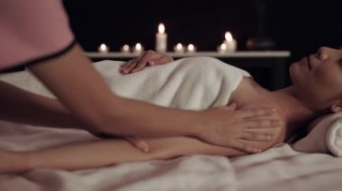 The masseur is giving a massage to a beautiful woman in the spa, taking care of the skin to be more beautiful inside the spa