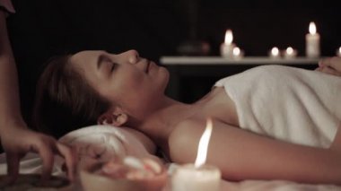 Spadaki masöz, kaplıcadaki Asyalı masaj terapistinin yüzünü ve gözlerini beslemek için salatalık dilimleri kullanıyor..