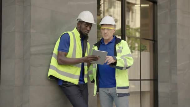 Starszy Biały Inżynier Omawia Pracę Afroamerykańskim Inżynierem Zewnątrz Budynku — Wideo stockowe