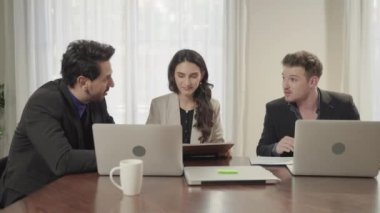 İş ekibi, ofis içinde iş amaçlarını tartışmak ve beyin fırtınası yapmak için toplanıyor..