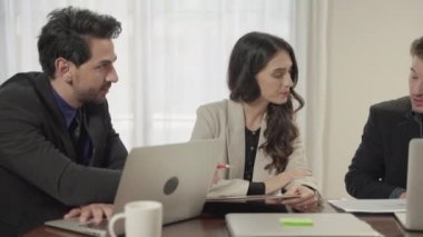 İş ekibi, ofis içinde iş amaçlarını tartışmak ve beyin fırtınası yapmak için toplanıyor..