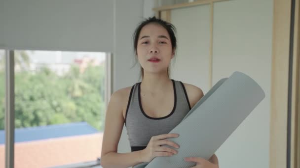 Piękna Azjatka Stroju Gimnastycznym Trzymająca Matę Jogi Przemawia Kamery Aby — Wideo stockowe