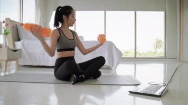 Güzel Asyalı kadınlar sosyal medya egzersizlerinde dambıl yerine su şişelerinin nasıl kullanılacağını gösteriyorlar.