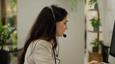 Çağrı merkezinin yanında, tele pazarlama, müşteri destek acentesi telefon görüşmesinde hizmet sunuyor, iş kadını kulaklık takıyor, uzaktan müşteri ya da iş arkadaşını desteklemek için ofiste çalışıyor..