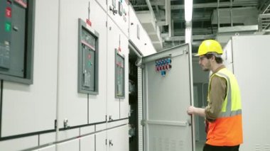 Elektrik ve Enstrüman teknisyeni güneş enerjisi üretiminin elektrik kontrol panelini kontrol ediyor