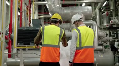 Mühendis ve Foreman fabrika kazan dairesinin planının planını tartışıyorlar.