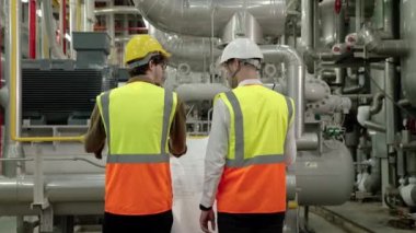 Mühendis ve Foreman fabrika kazan dairesinin planının planını tartışıyorlar.