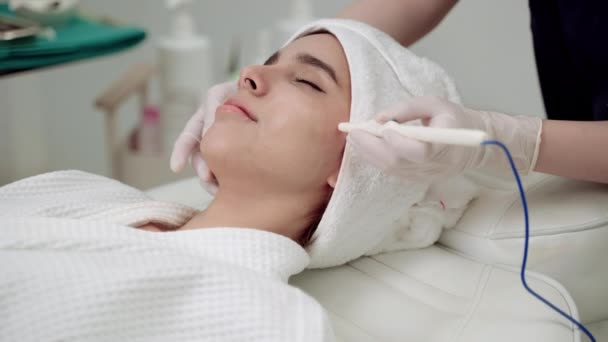美容クリニック美しい女性が顔を治療してる 美容クリニックの顔の治療皮膚のツールプロセスを使用してクリニックで医師や看護師 医者は顔に化粧手順を実行します — ストック動画