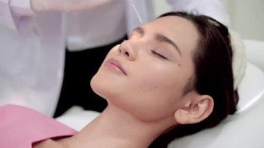 Kozmetik cerrahi kliniği. Doktorlar, yüzlerini daha güzel yapmak isteyen genç kadınlara ilaç enjekte ediyorlar..