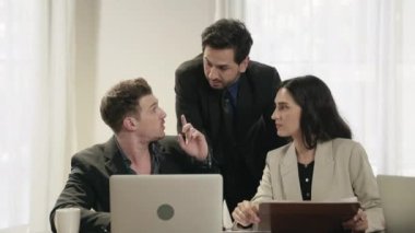 İş ekibi salonda başarılarını kutluyor ve sohbet ediyor..