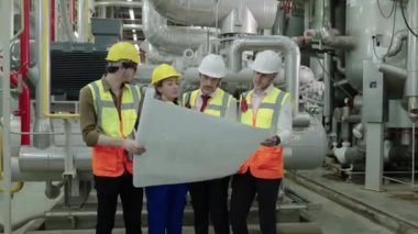 Mühendis ve Foreman 'ın 50 penilik çerçeve görüntüsü fabrika kazan dairesinin planının planlarını tartışıyor.