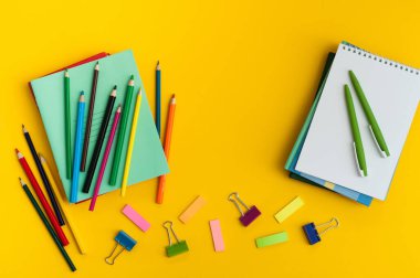 Mavi arka planda bir okul konusu çerçevesi. Cetvel, makas, hesap makinesi, kalemler. Yukarıdan görüntüle