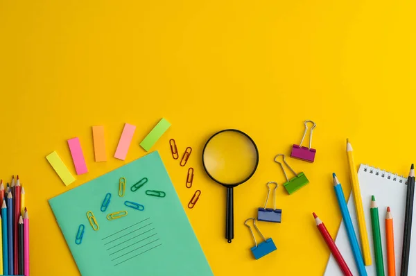 Mavi arka planda bir okul konusu çerçevesi. Cetvel, makas, hesap makinesi, kalemler. Yukarıdan görüntüle