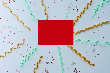 Kırmızı kurdele hediye paketi ve altın yıldızlı Noel kartı, beyaz arka planda örülmüş süveter yılanı. Uzayı kopyala Düz yatıyordu