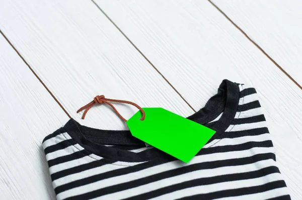 Beyaz arkaplanda alışveriş etiketi olan bir sürü polo gömlek. Kara Cuma. Yukarıdan görünüm.