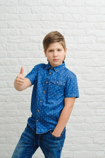 Мальчик Европейского Появления Голубой Рубашке Светлом Фоне Показывает Большие Пальцы — стоковое фото
