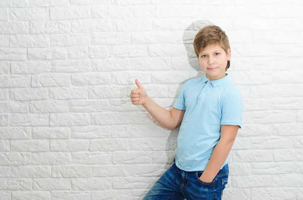 Chłopiec Europejski Wygląd Niebieskiej Koszuli Jasnym Tle Pokazuje Kciuki Górę — Zdjęcie stockowe