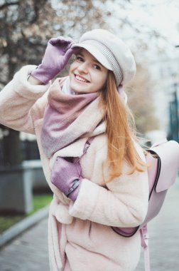 Kısa açık renk saçlı, kırmızı dudaklı, siyah ceketli, pembe atkı takan, park geçmişi olan, portresi olan tatlı bir kız..